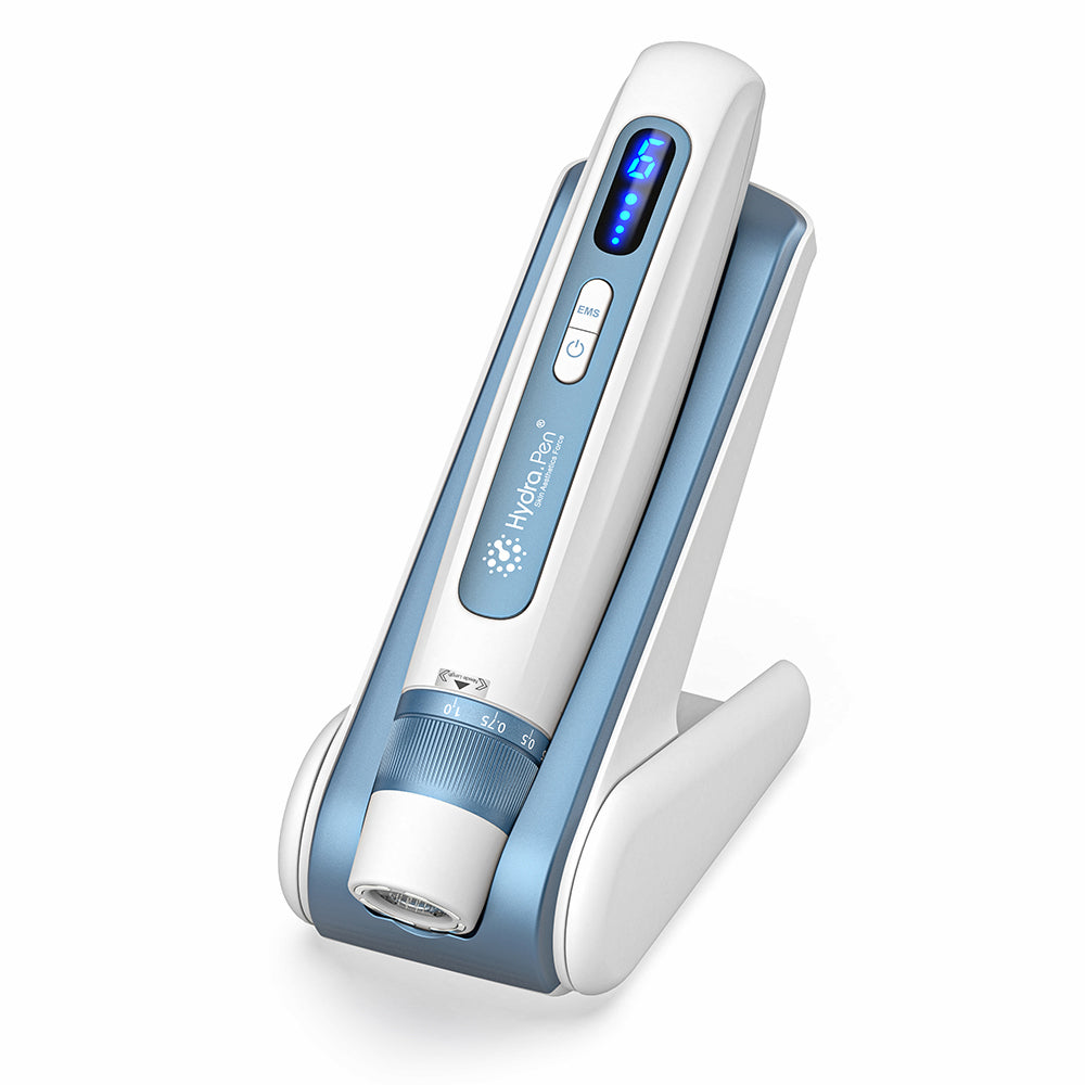 HydraPen H5 biela a modrá microneedling-pero stojace vo svojej nabíjacej stanici, pokročilé mikroneedlingové zariadenie pre infúziu séra a ošetrenie pokožky.