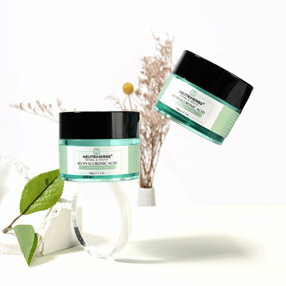 Lifestyle obrázok Neutriherbs 4D Hyaluronic Acid Gel Moisturizer 50 g. Dva tégliky hydratačného gélového krému sú prezentované v svetlom a štýlovom prostredí s prírodnými detailmi, ktoré navodzujú sviežu rutinu starostlivosti o pleť a intenzívnu hydratáciu.