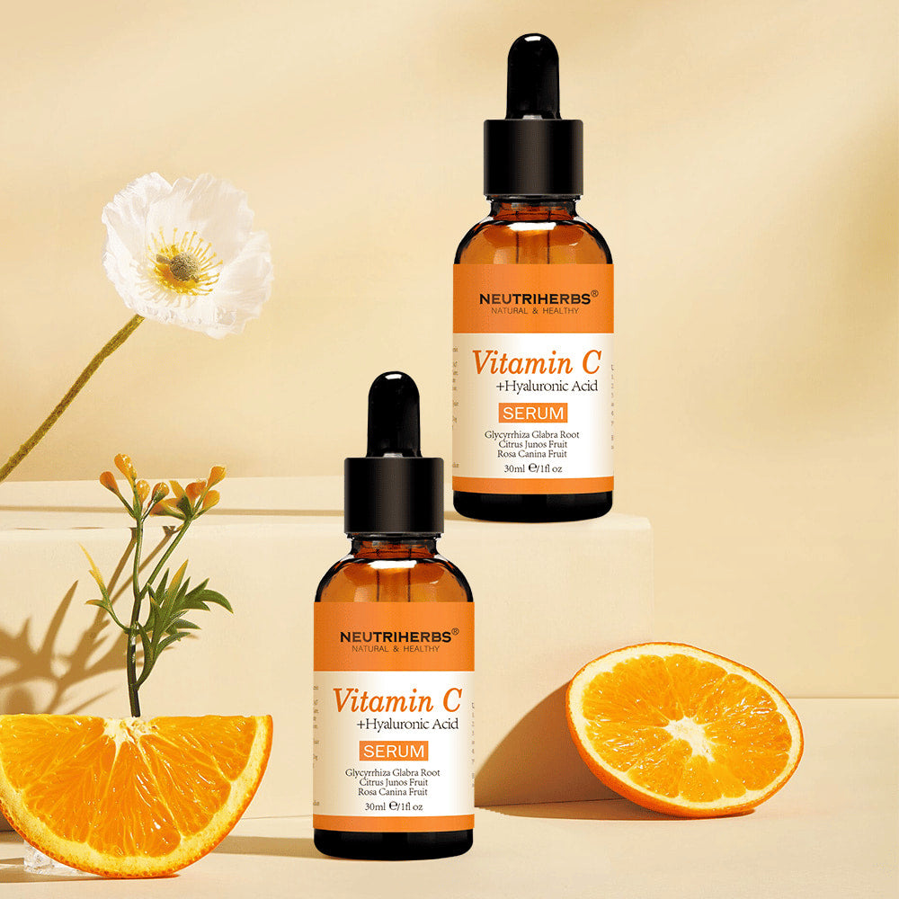 Neutriherbs Vitamin C + Hyaluronic Acid Serum 30 ml spolu s čerstvými pomarančmi a kvetmi. Inšpiratívny produktový obrázok, ktorý zdôrazňuje obsah vitamínu C v sére pre hydratovanú pokožku, väčší jas a rovnomernejší tón pleti.